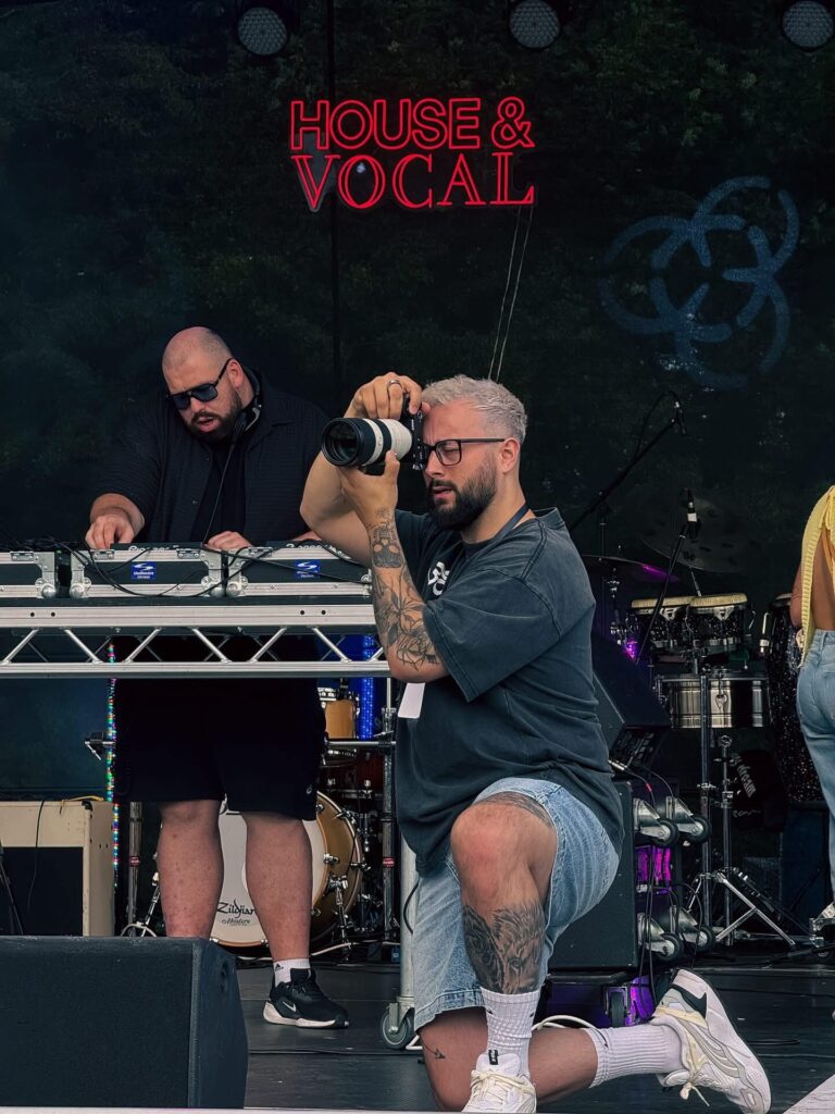 Professional photographer and videographer capturing live event performance on stage