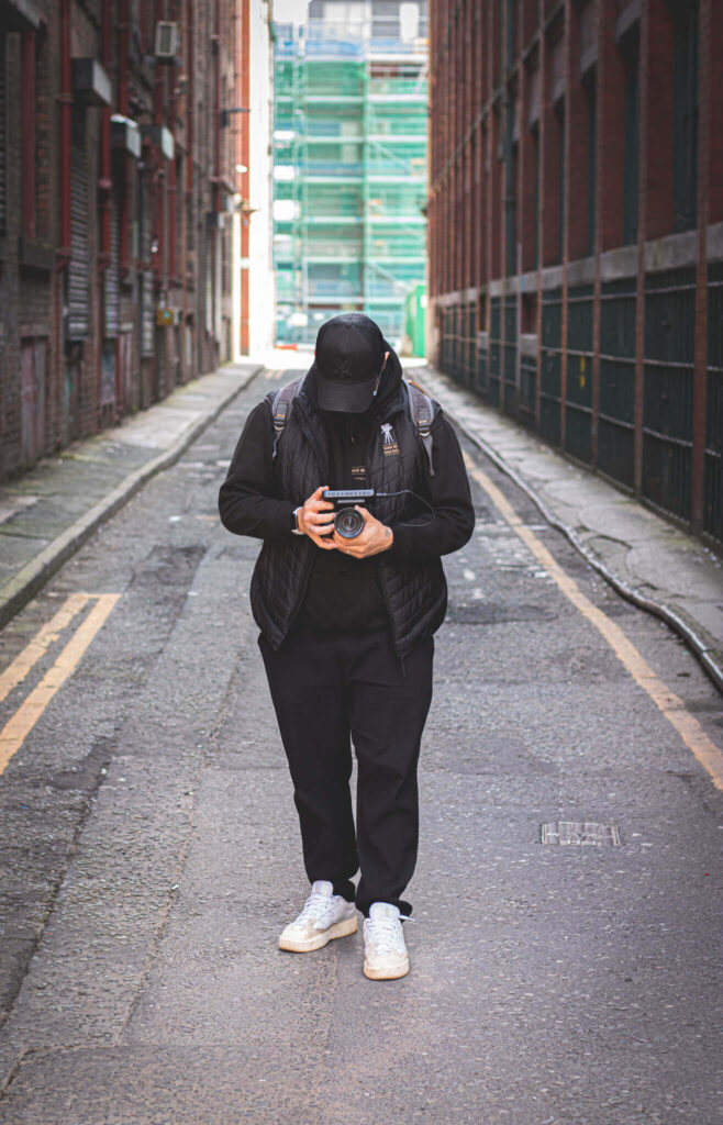 Professional photographer and videographer walking through city street with camera