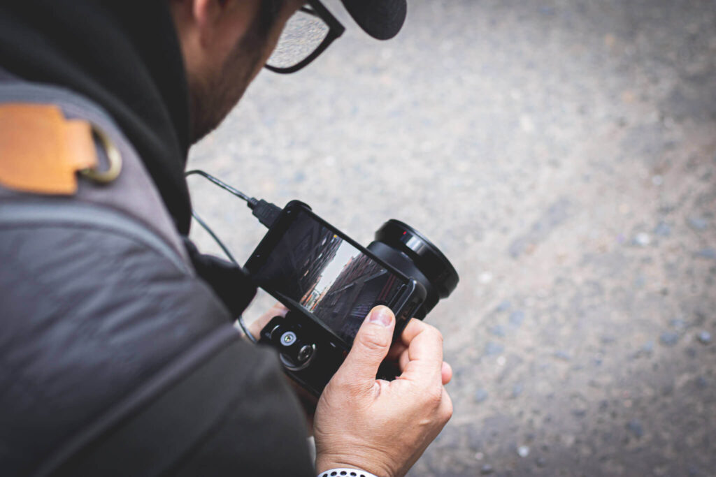 Professional photographer and videographer reviewing footage on camera screen during shoot